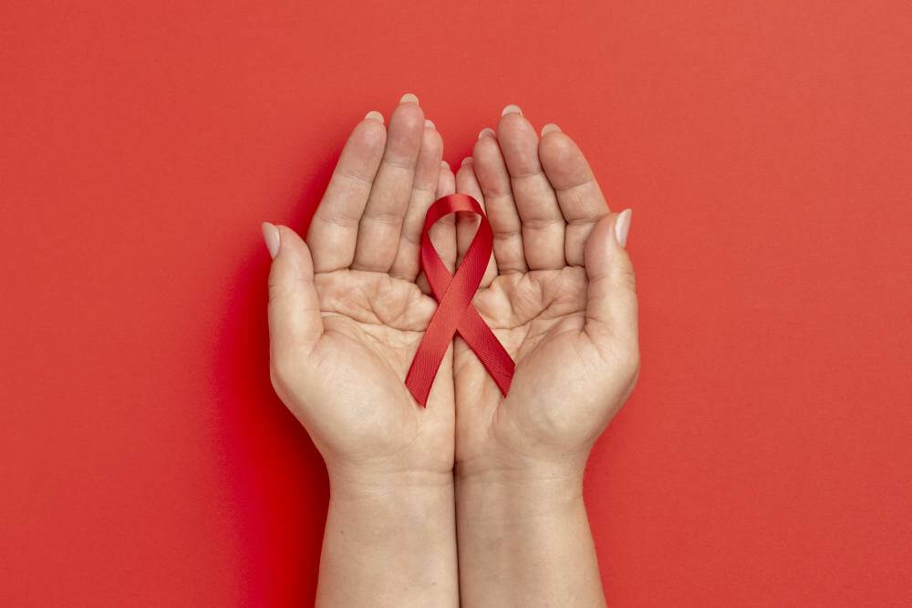 person holding an world aids day ribbon